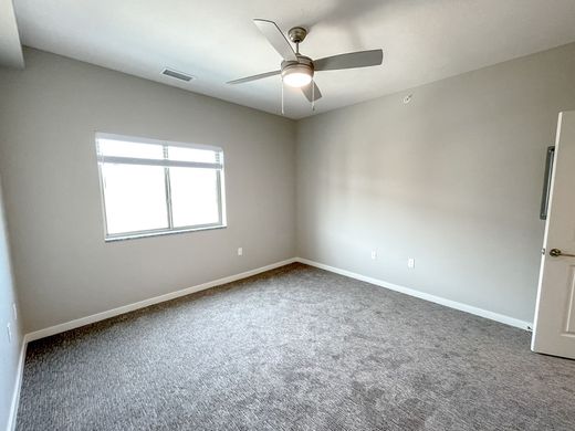 An empty bedroom with a ceiling fan and a window.