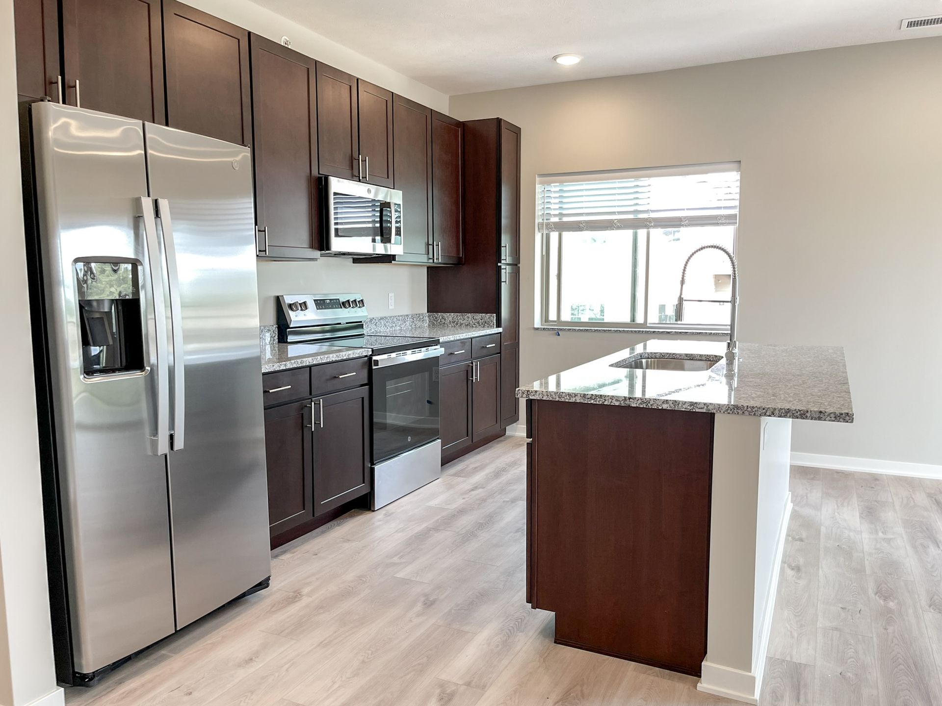 A kitchen with stainless steel appliances and wooden cabinets