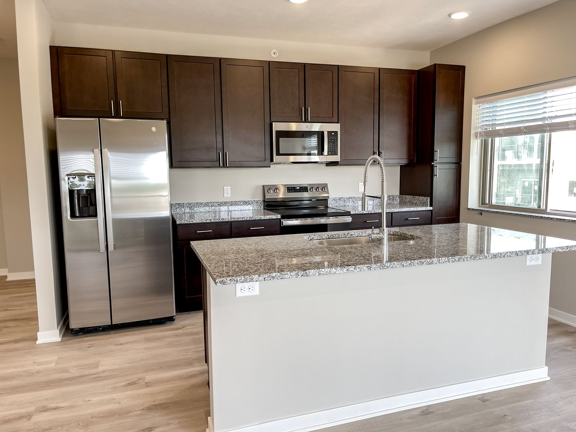 A kitchen with stainless steel appliances and granite counter tops.