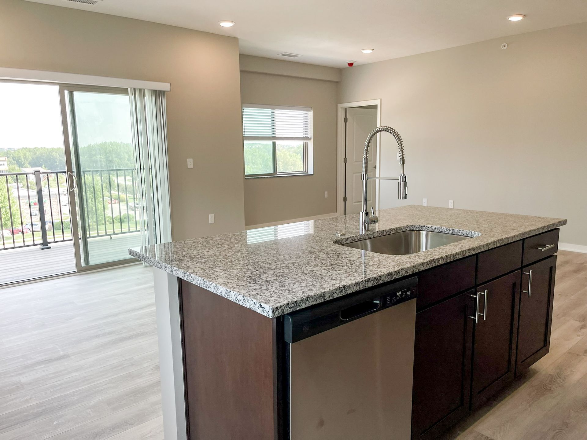 A kitchen with granite counter tops , stainless steel appliances , and a large island.