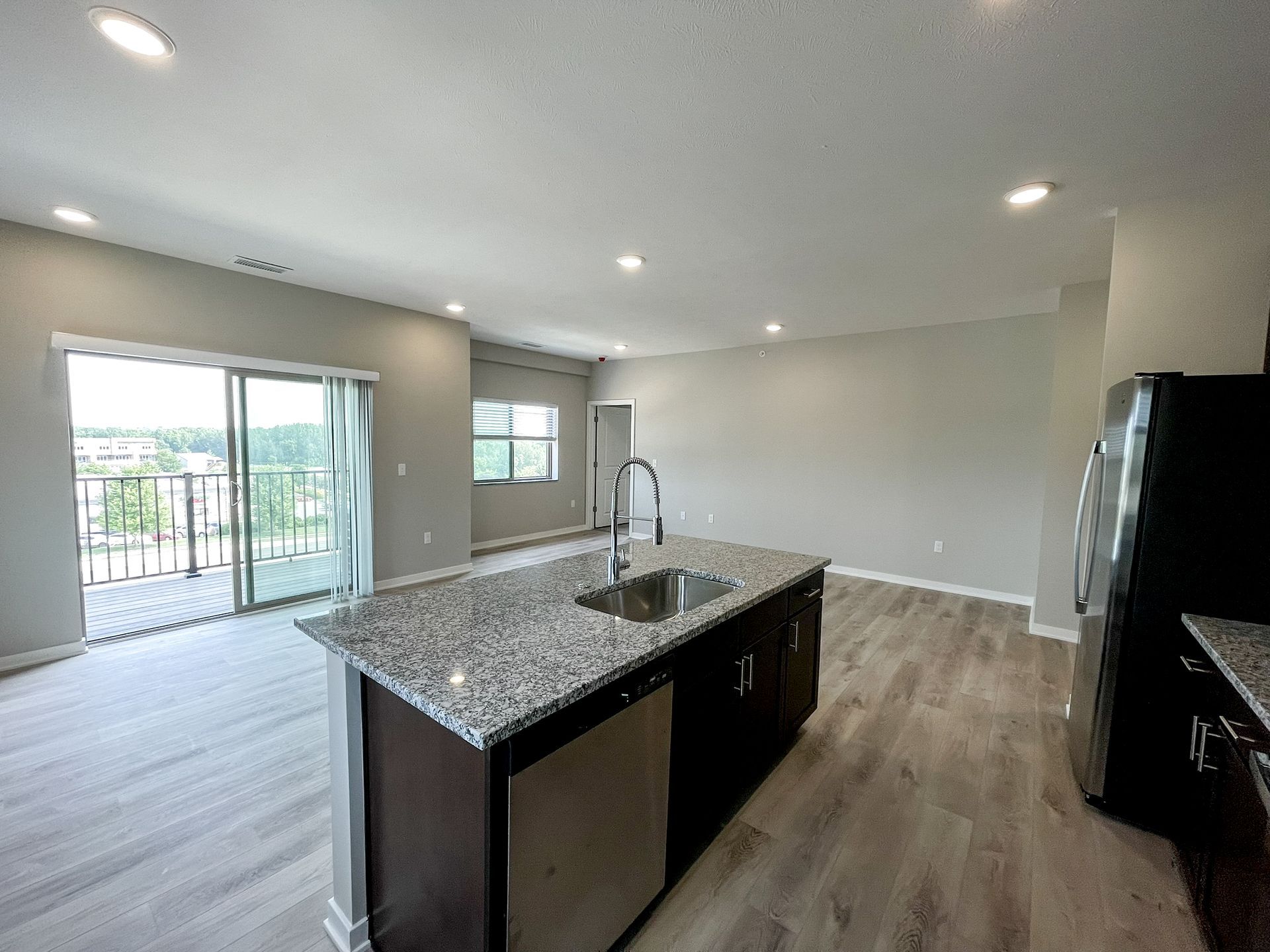 A kitchen with granite counter tops , stainless steel appliances , and a large island.