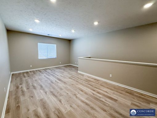 An empty living room with hardwood floors and a window.