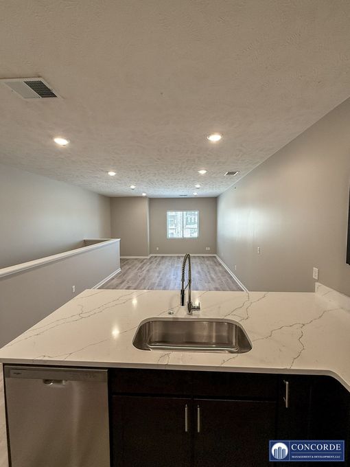 A kitchen with a stainless steel sink and a stainless steel dishwasher.