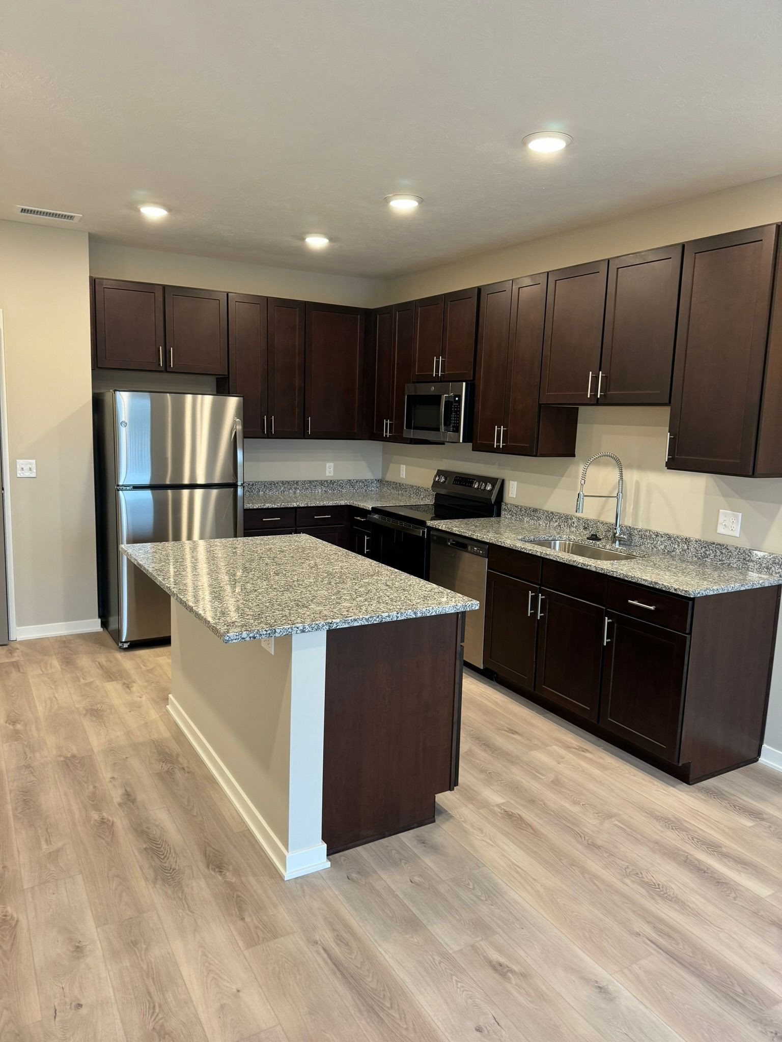 A kitchen with stainless steel appliances and granite counter tops.