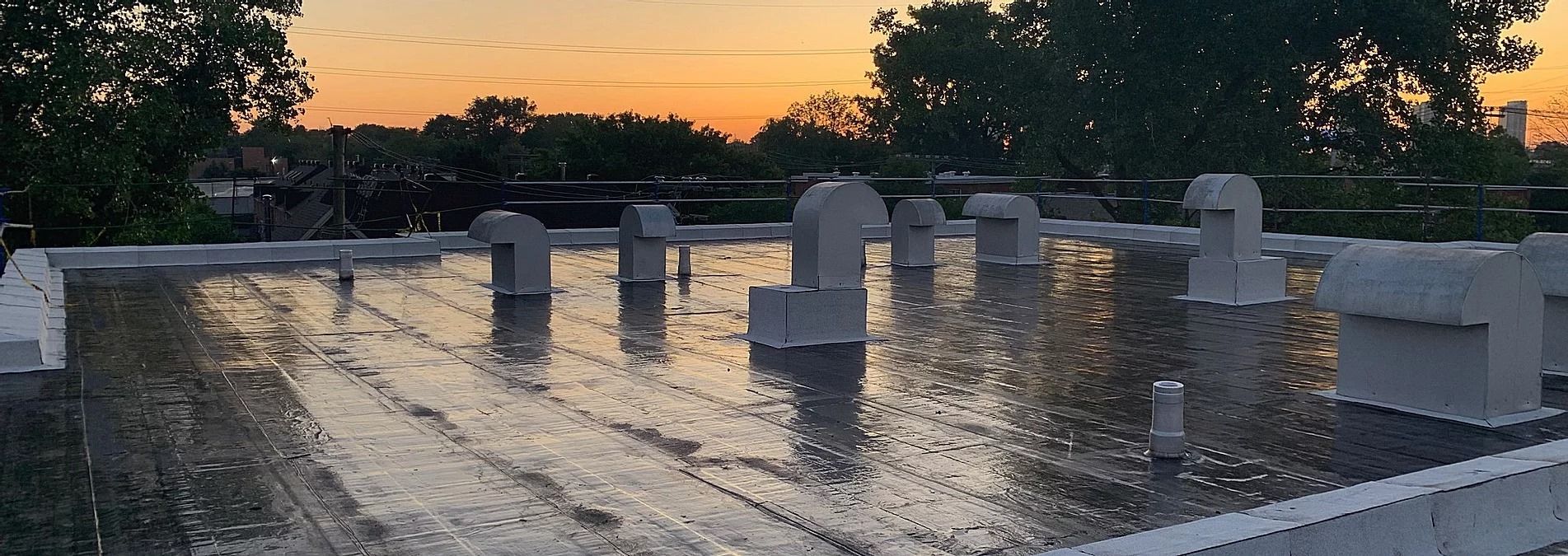 Un toit avec beaucoup d'eau dessus et un coucher de soleil en arrière-plan.