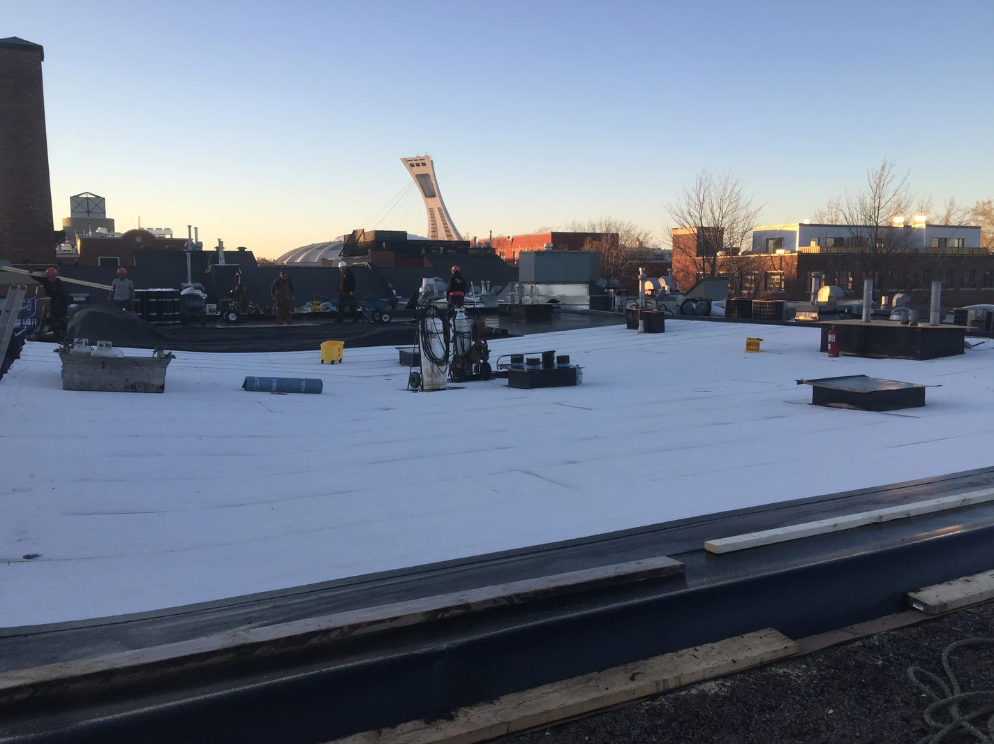 Un toit avec beaucoup de neige dessus et beaucoup de bâtiments en arrière-plan.