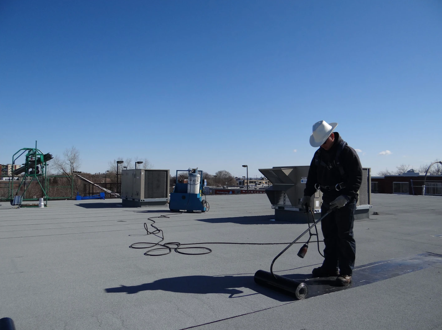 Un homme portant un casque de sécurité travaille sur un toit