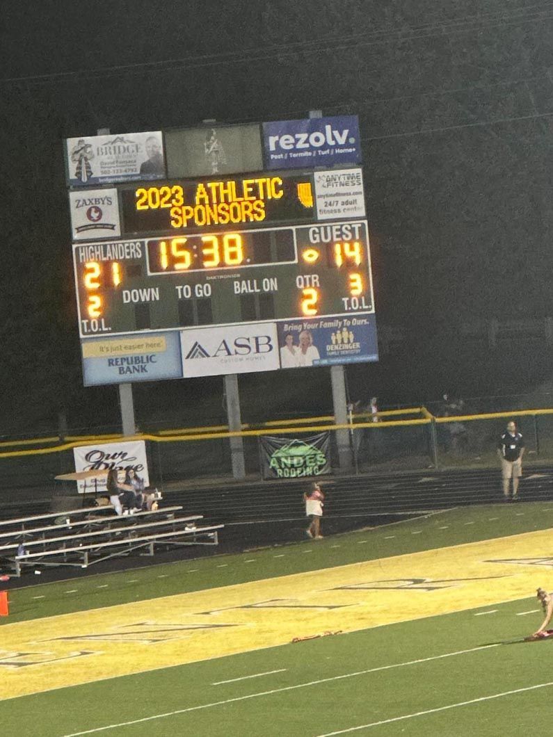 A football field with a scoreboard that says 2023 athletic sponsors