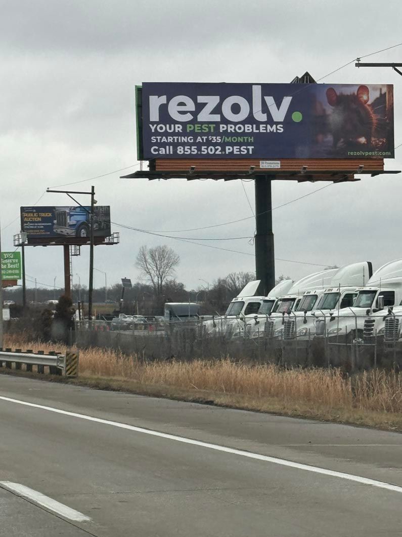A billboard on the side of a highway that says rezolv
