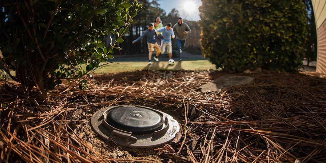 A family is standing in front of a septic tank.