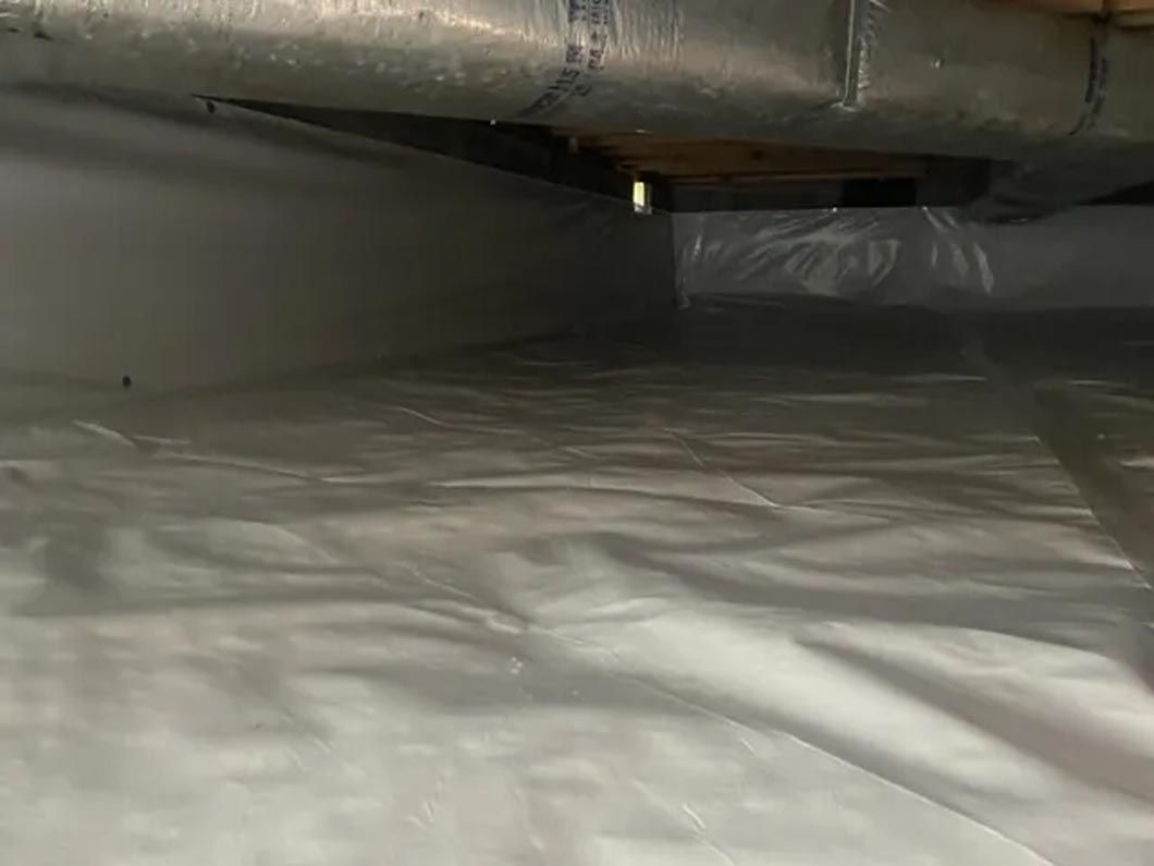 A close up of a crawl space filled with plastic.