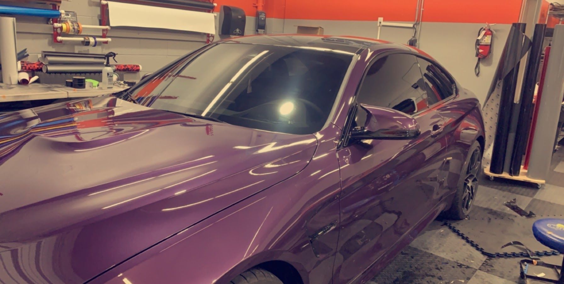 A purple car is parked in a garage.