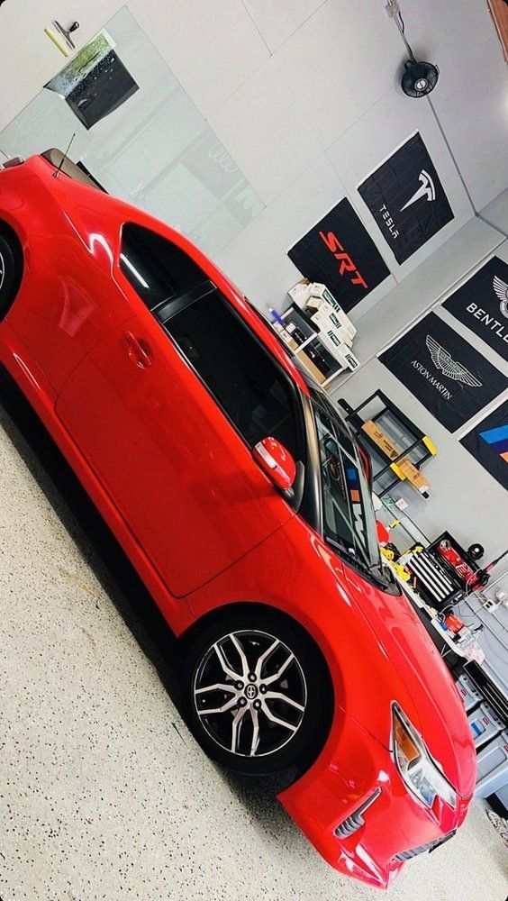 A red car is parked in a garage.