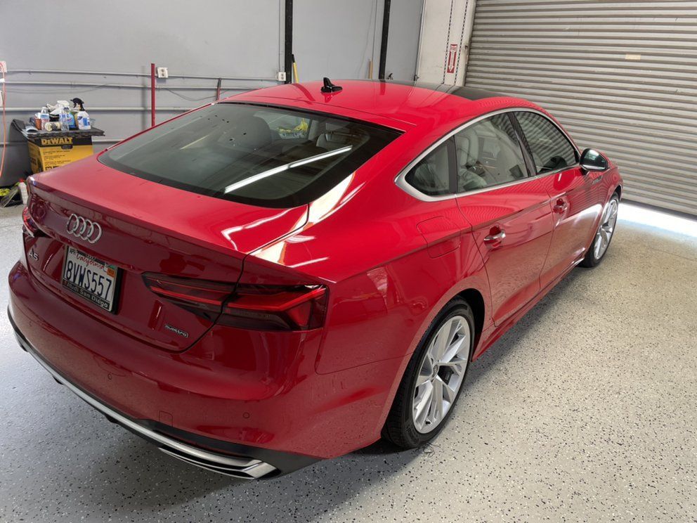 A red audi a5 is parked in a garage.