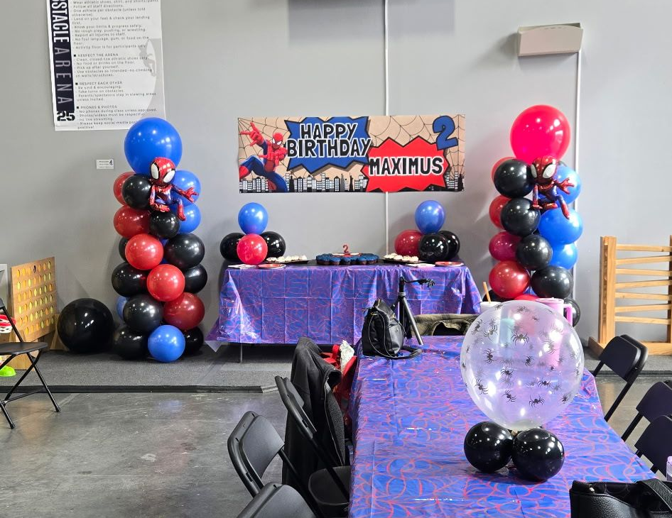 Children blowing out candles on a birthday cake; indoors.