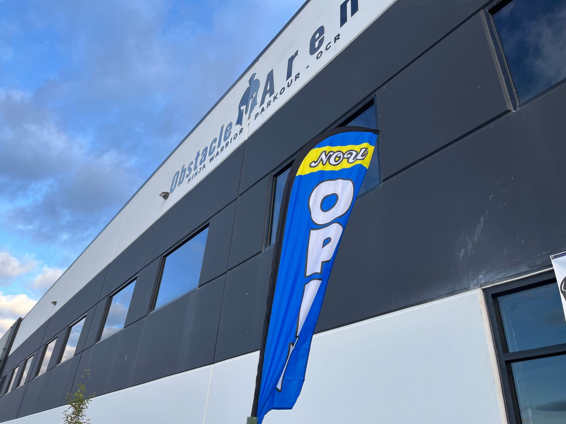 Exterior of a building with blue and white accents, an open sign visible.