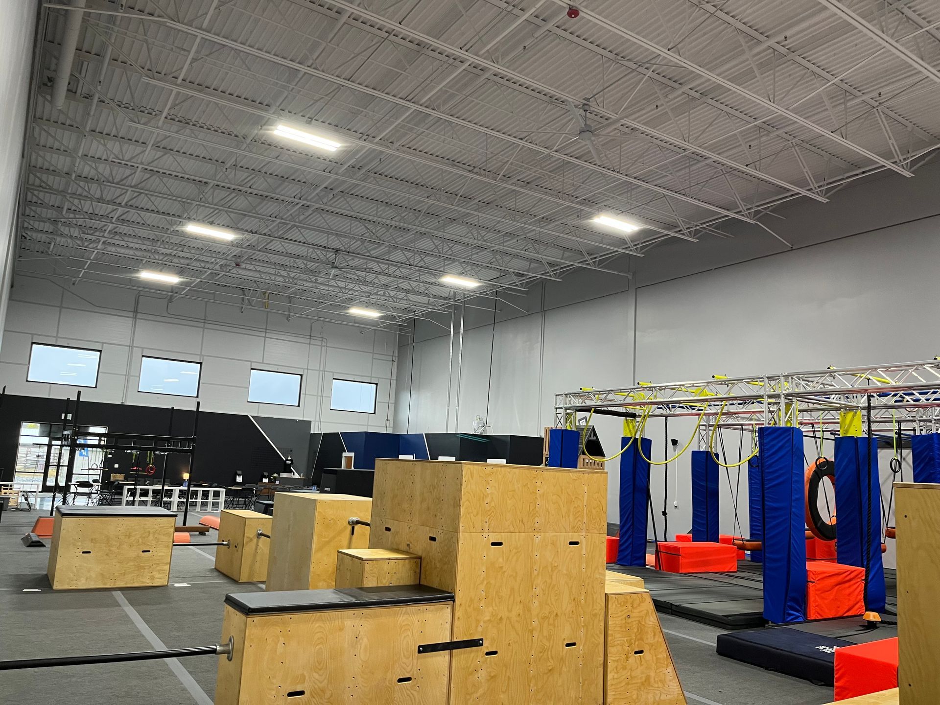 Indoor obstacle course with wooden structures and padded elements.