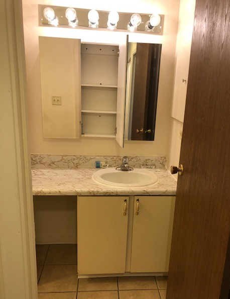 A bathroom with a sink a mirror and a medicine cabinet