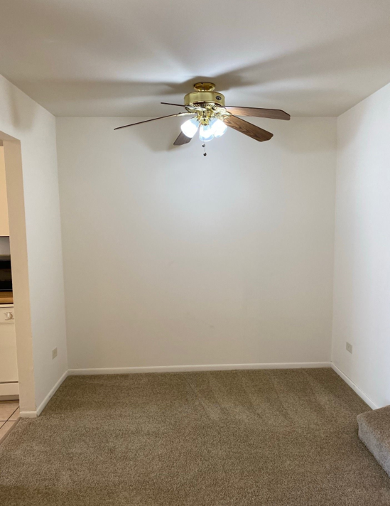 There is a ceiling fan in the corner of the room.