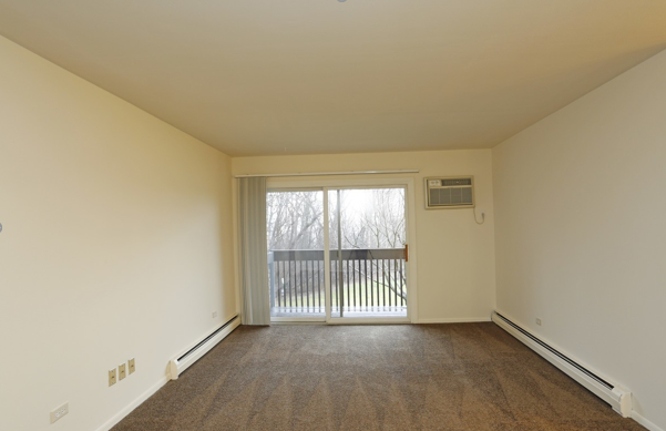 An empty living room with a balcony and sliding glass doors