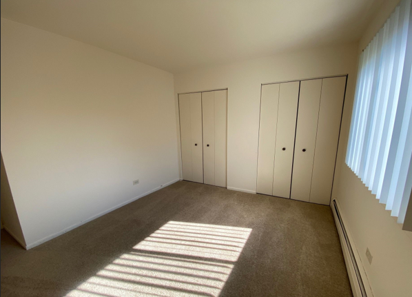 A bedroom with a lot of closets and a window