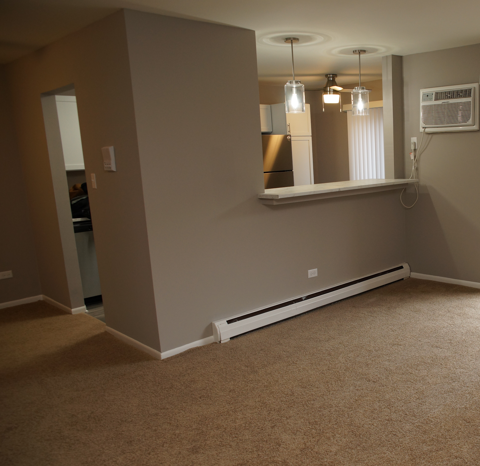 A living room with a carpeted floor and gray walls