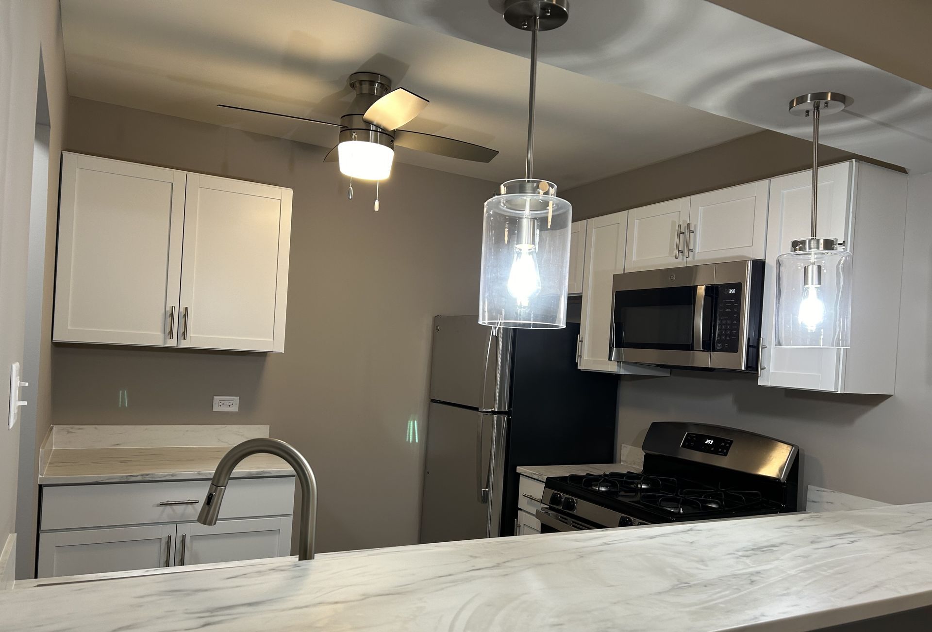 A kitchen with stainless steel appliances and white cabinets