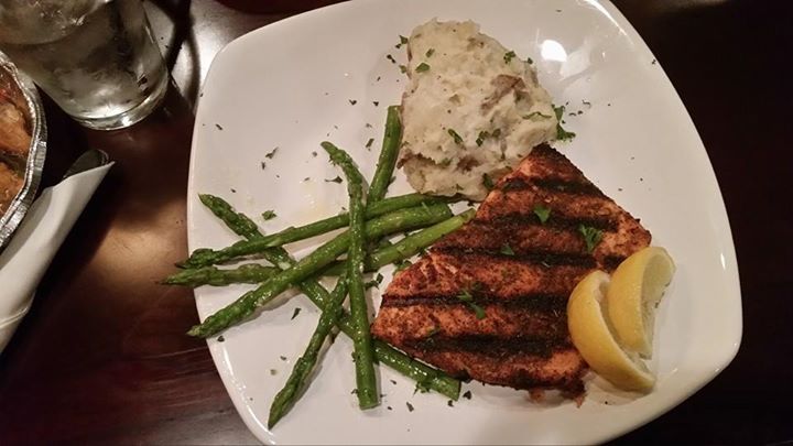 Grilled salmon with asparagus, mashed potatoes, and a lemon wedge on a white plate.