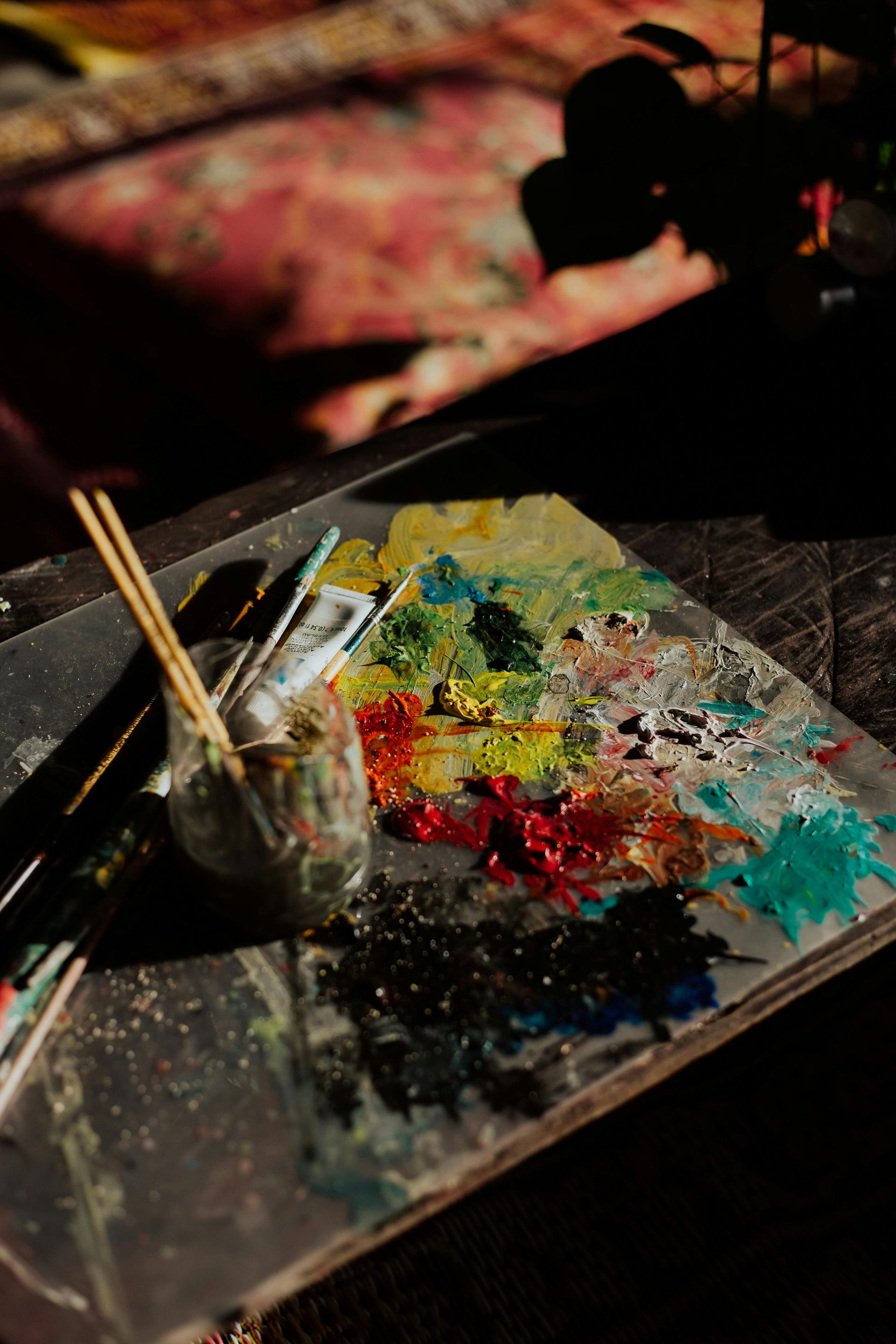 A palette of paint and brushes on a table.