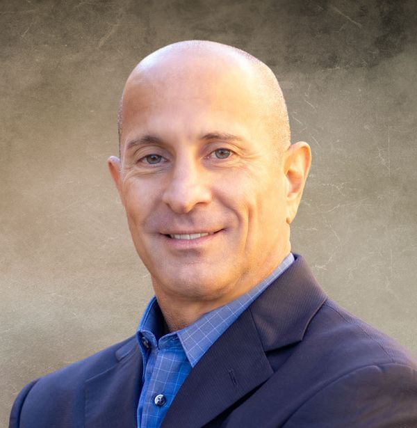 Laptop and tablet displaying financial charts on a wooden table.
