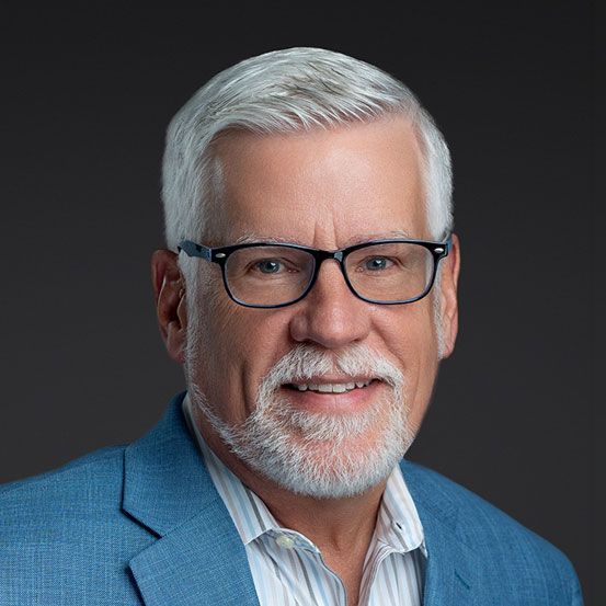 Laptop and tablet displaying financial charts on a wooden table.