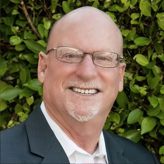 Laptop and tablet displaying financial charts on a wooden table.