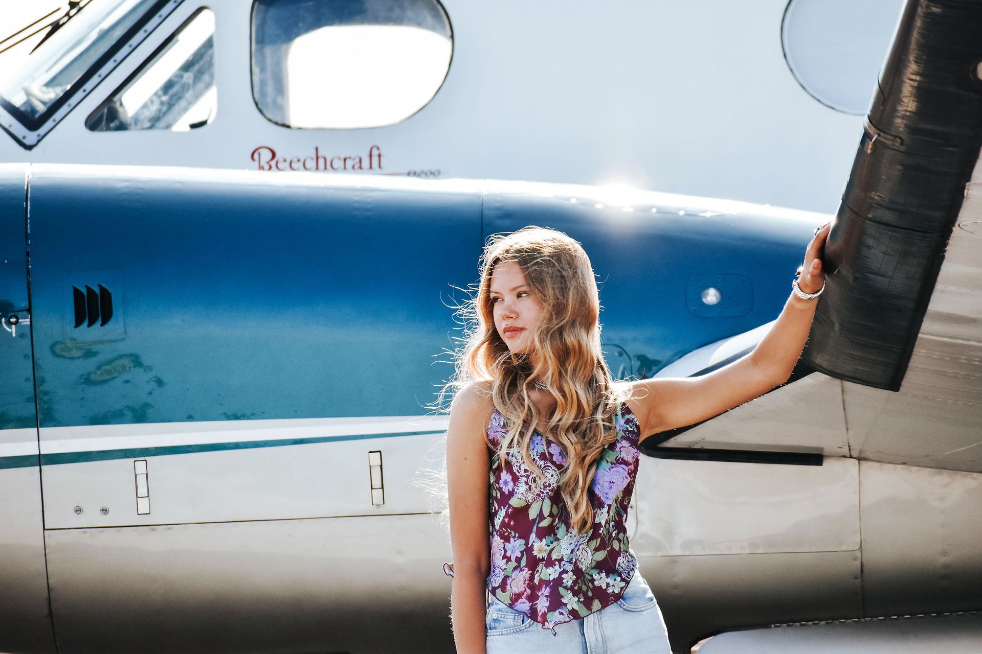A woman in a blue dress is standing in front of a building.