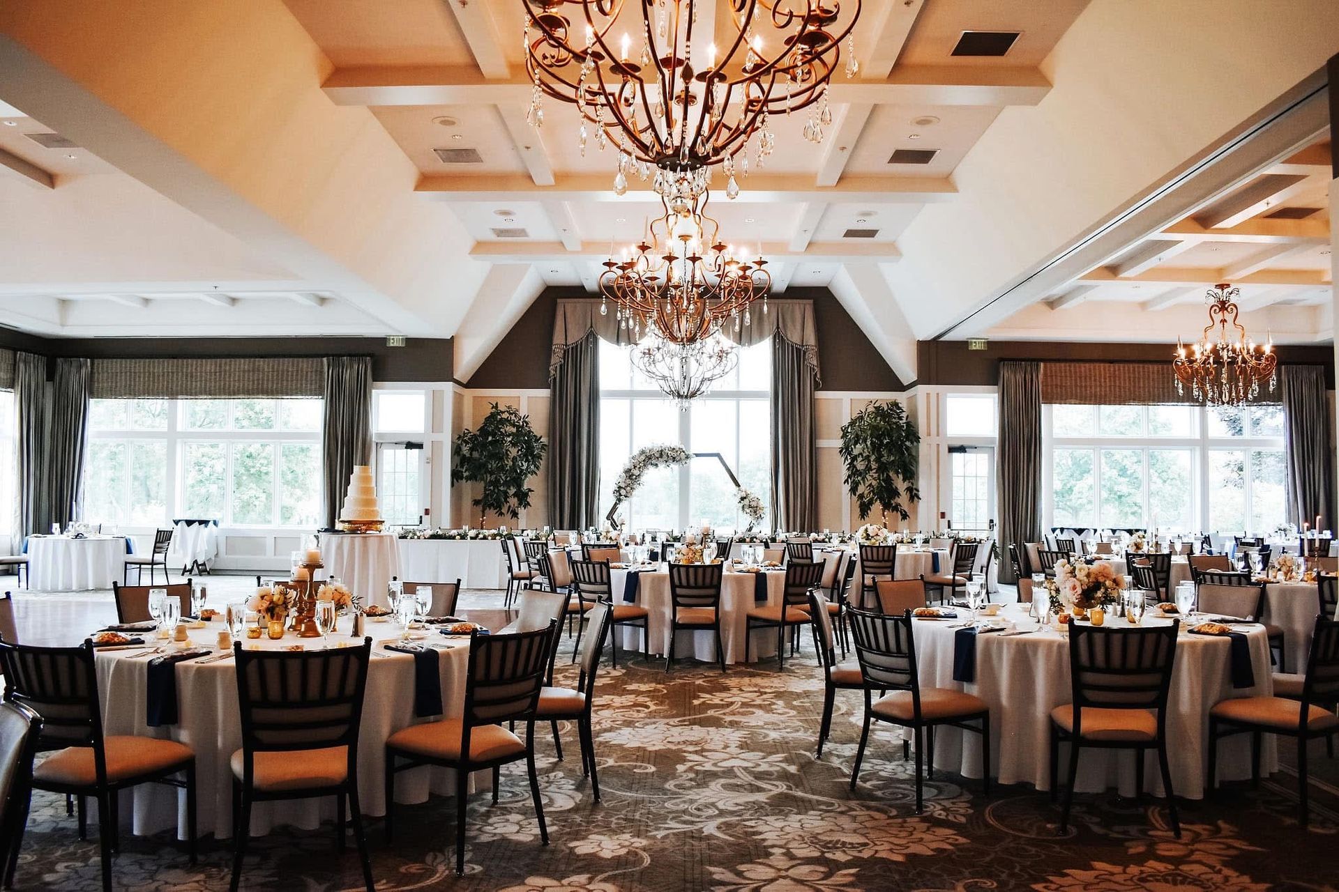 A large room with tables and chairs set up for a wedding reception.