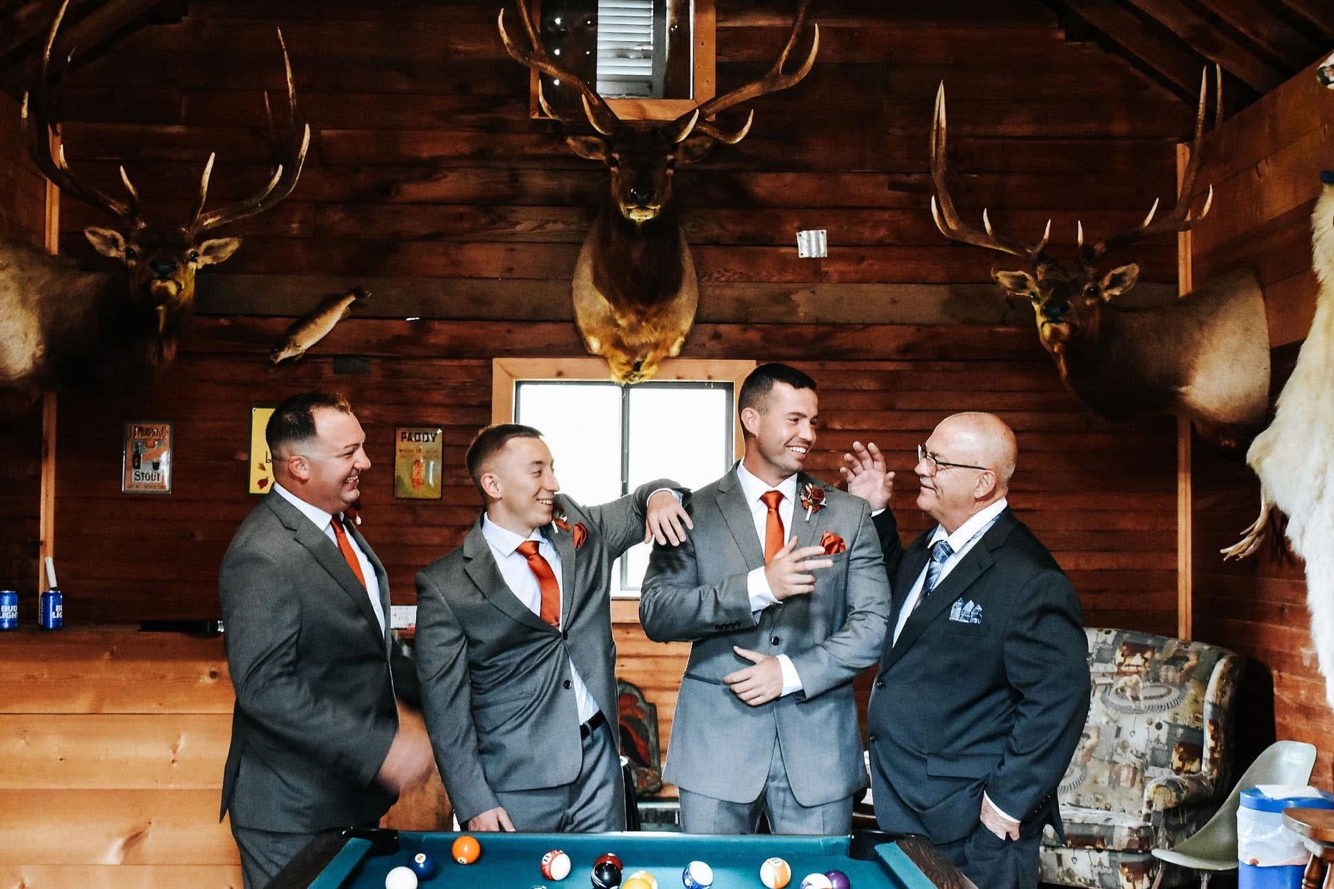 A group of men in suits are standing around a pool table.