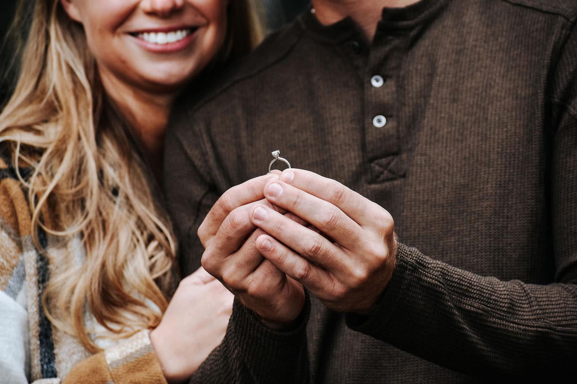 A man is giving a woman an engagement ring.