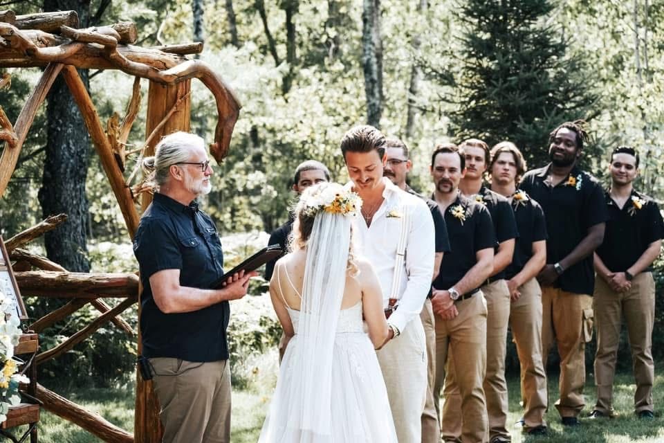 A bride and groom are getting married in the woods.