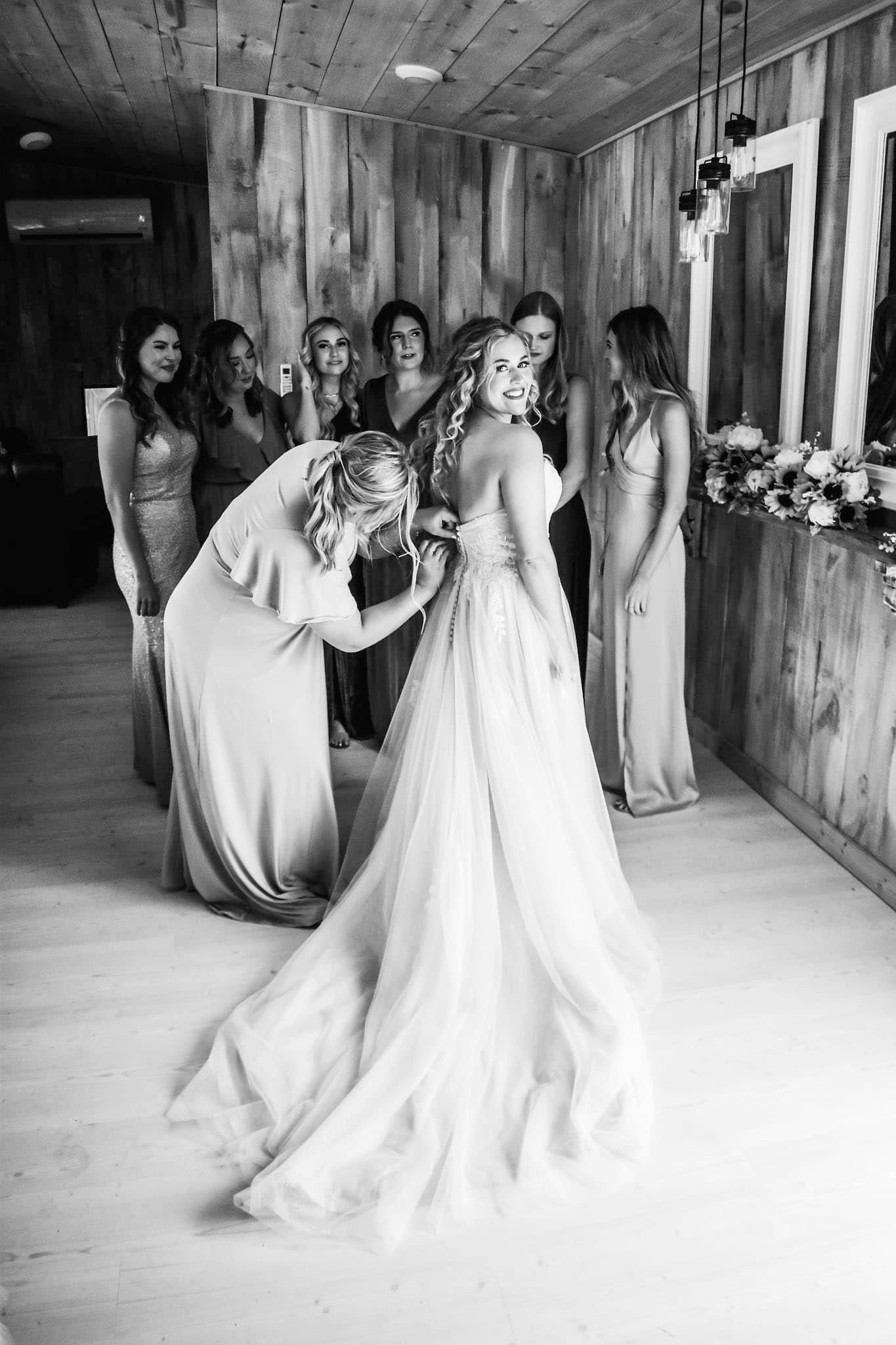 A black and white photo of a bride getting ready for her wedding.