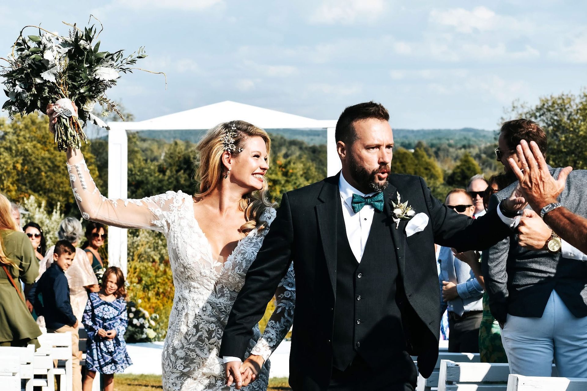 A bride and groom are walking down the aisle at their wedding.