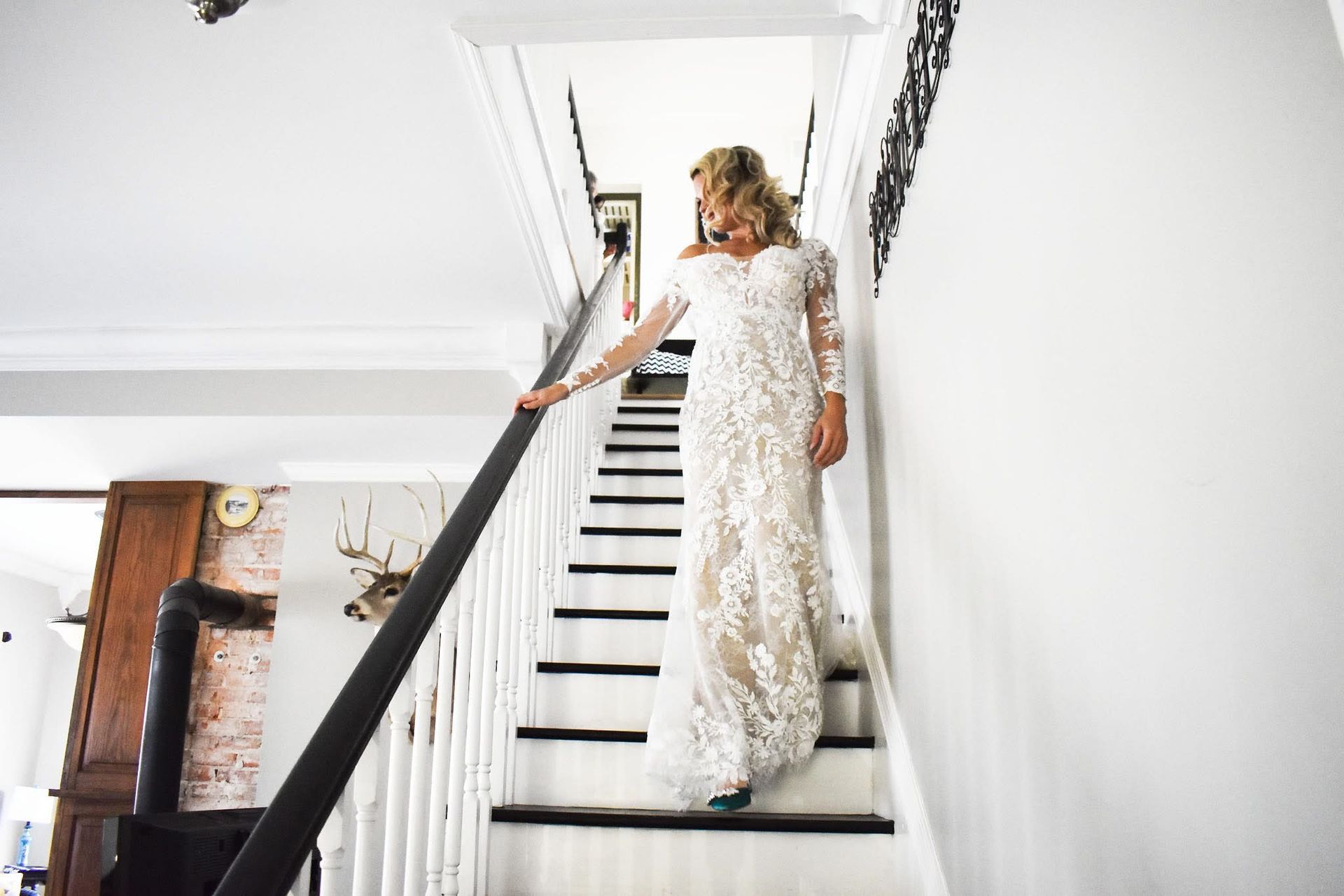 A woman in a wedding dress is walking down a set of stairs.