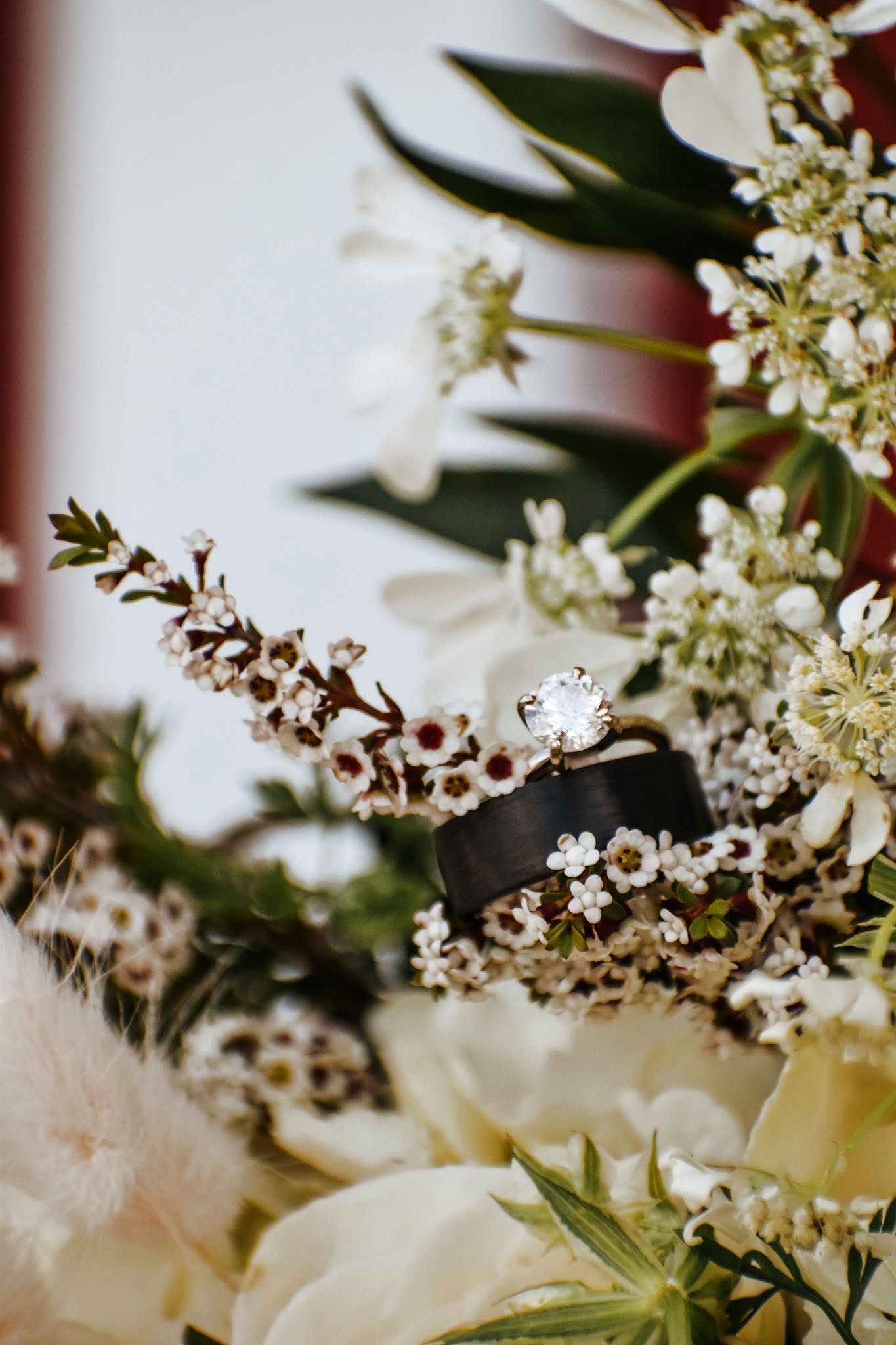 A close up of a wedding ring in a bouquet of flowers.