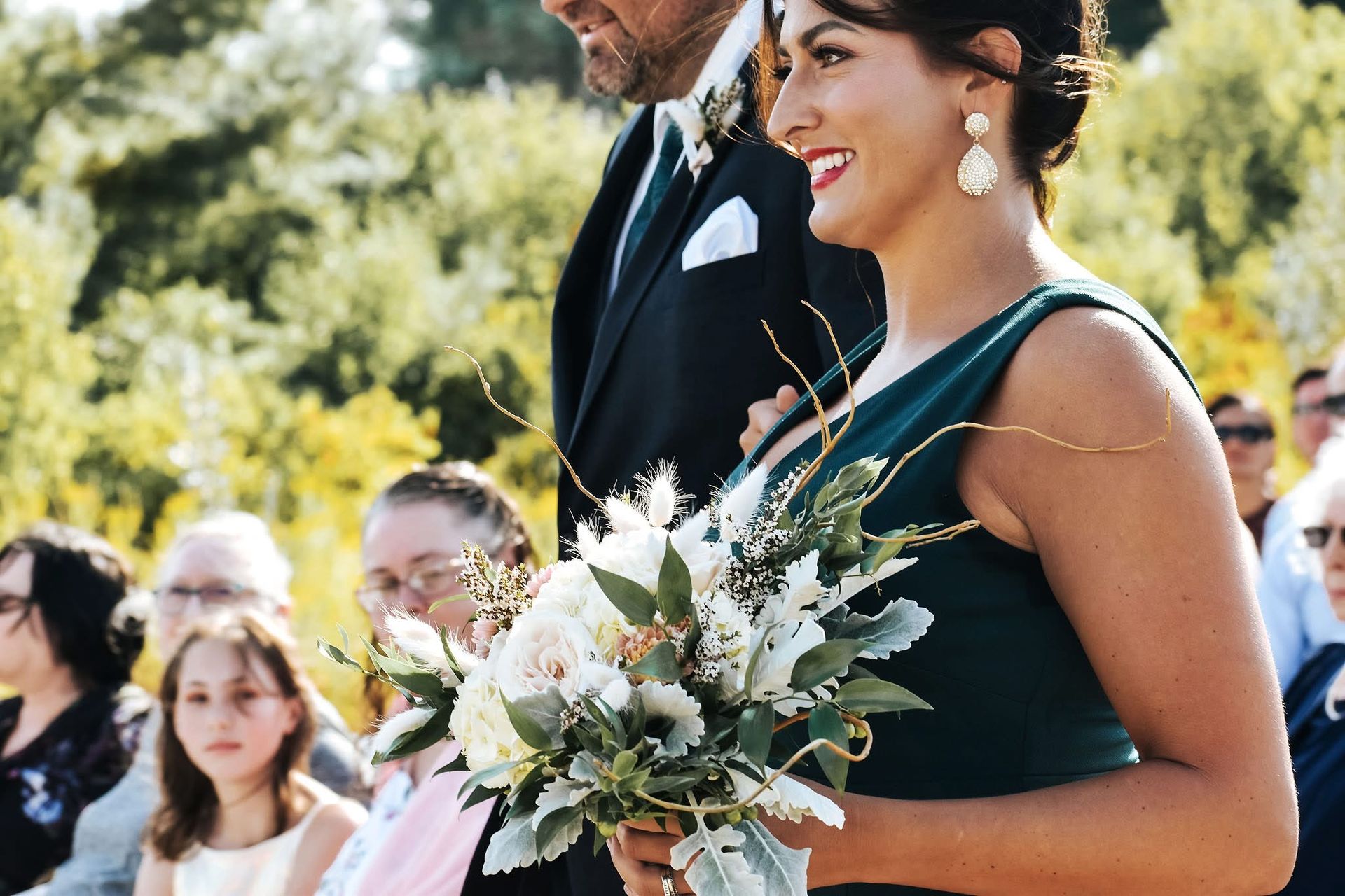 A man is walking a woman down the aisle at a wedding.