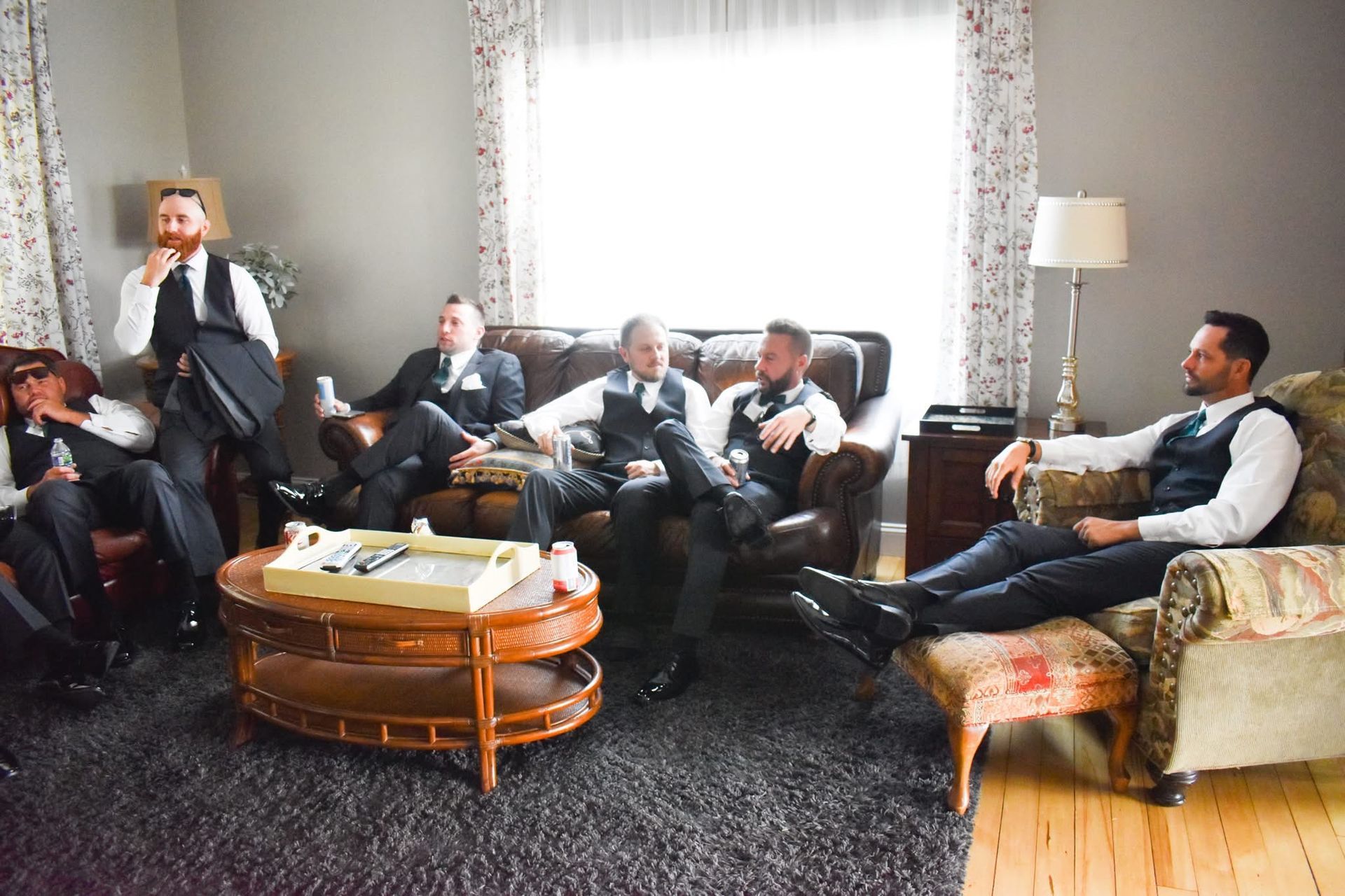 A group of men are sitting on a couch in a living room.