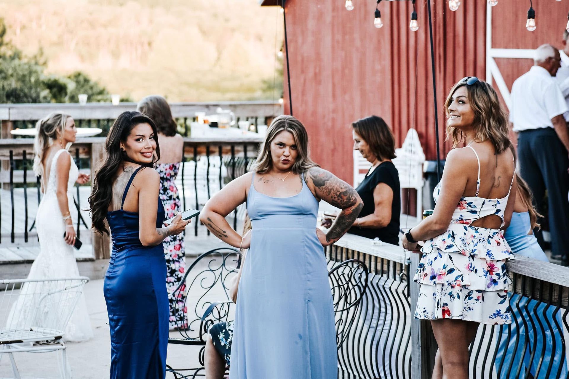 A group of women are standing next to each other on a balcony at a wedding.