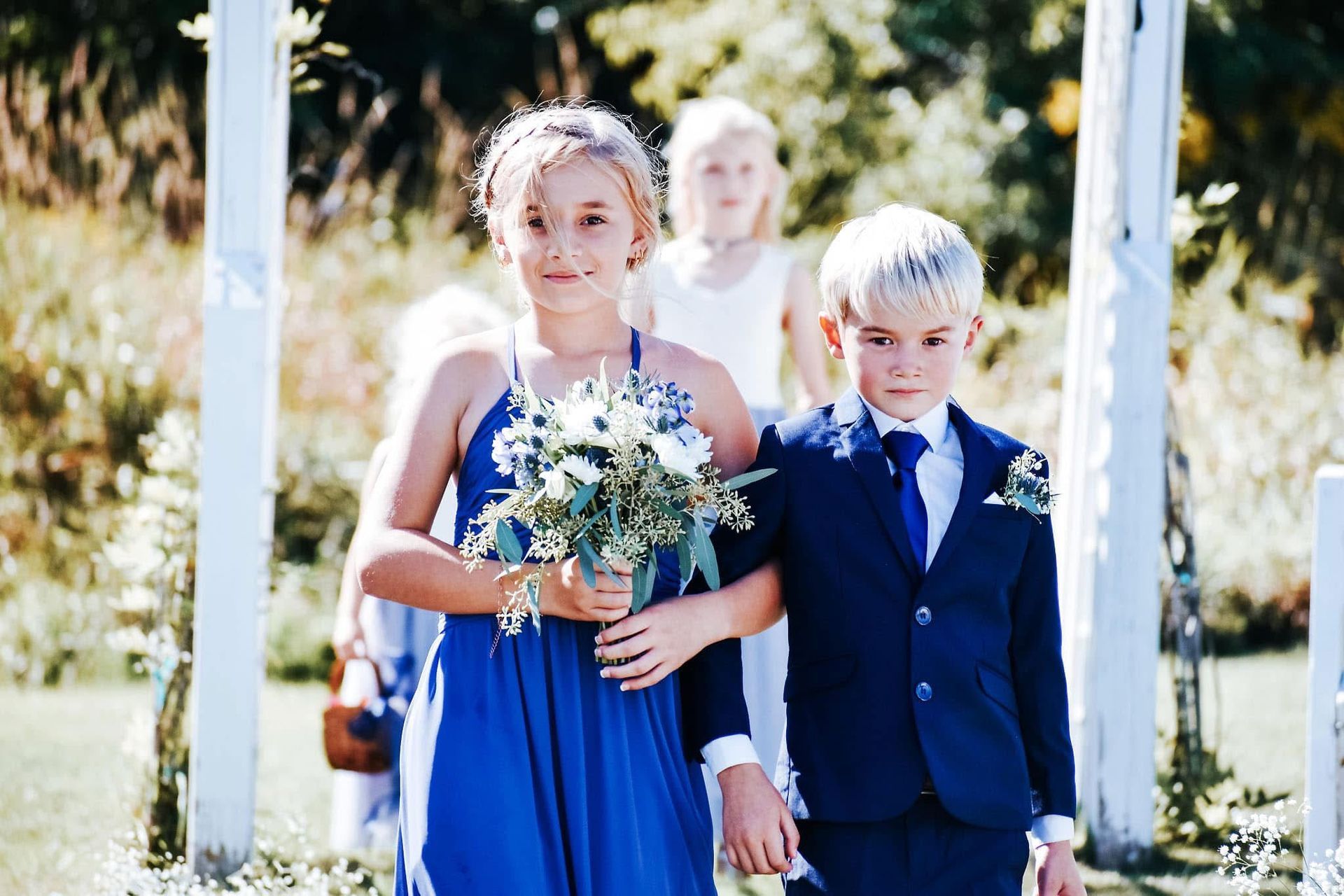 A boy and a girl are walking down the aisle at a wedding.