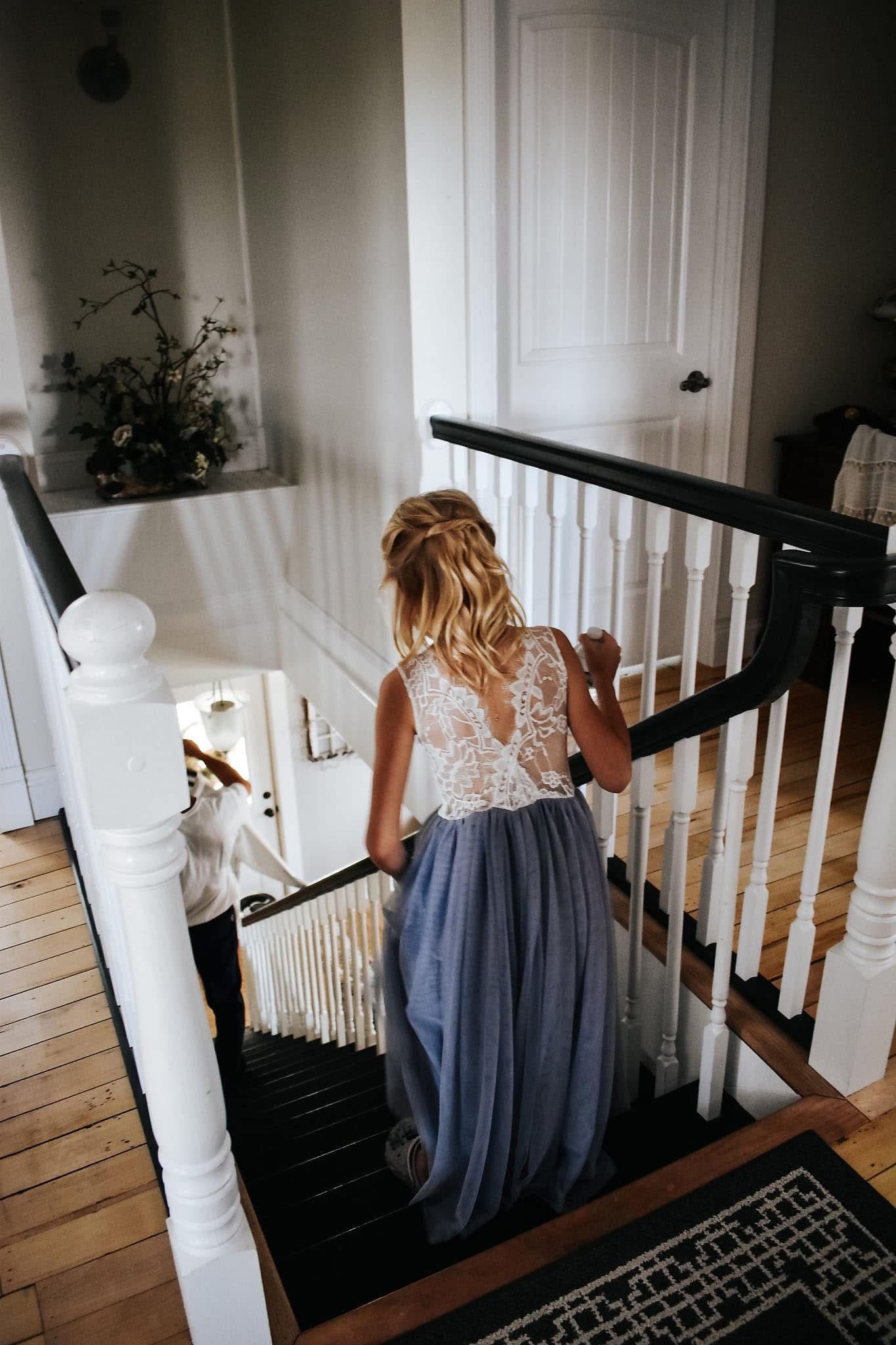 A woman in a blue dress is walking down a set of stairs.