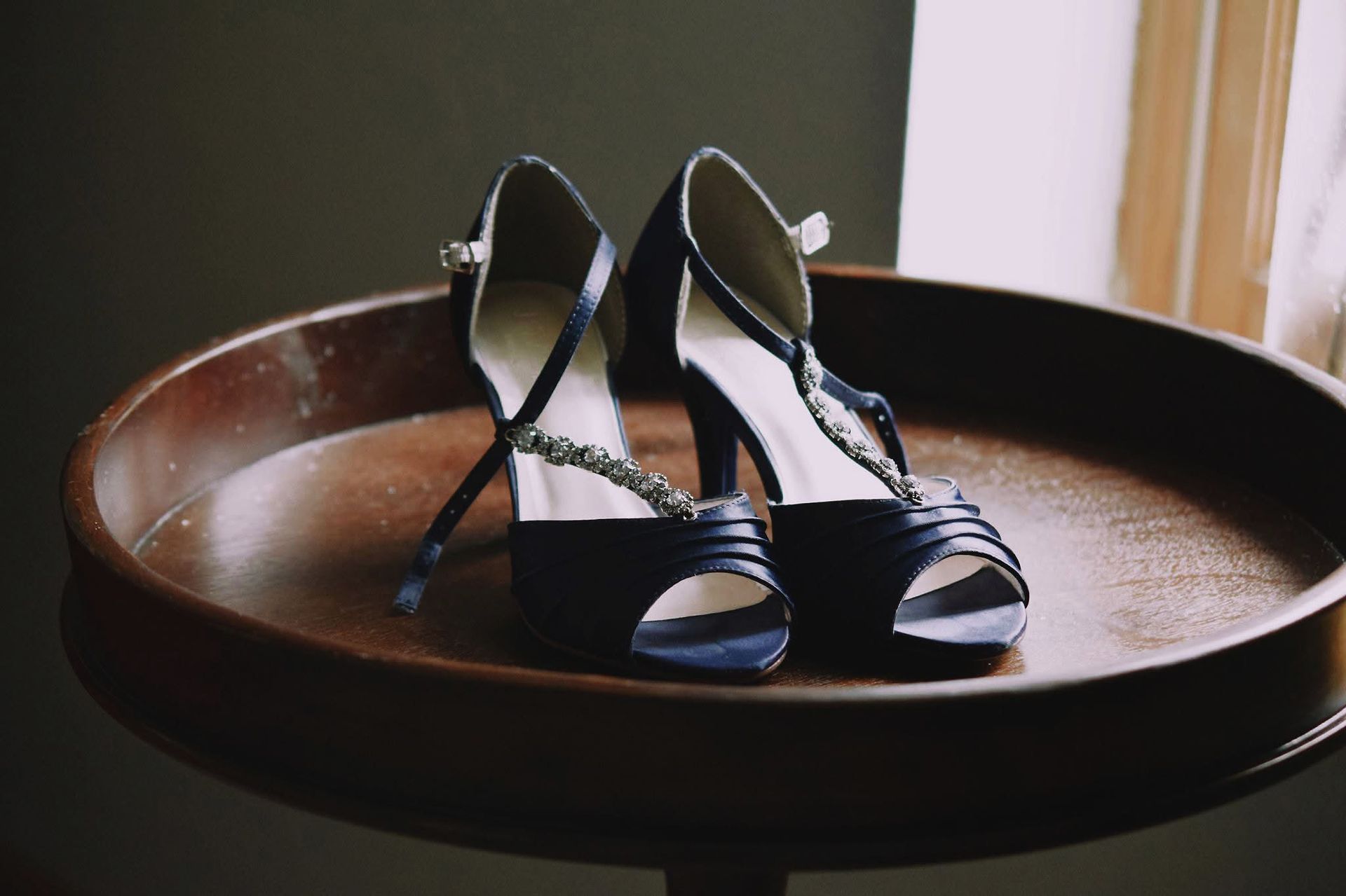 A pair of black shoes are sitting on a wooden table.