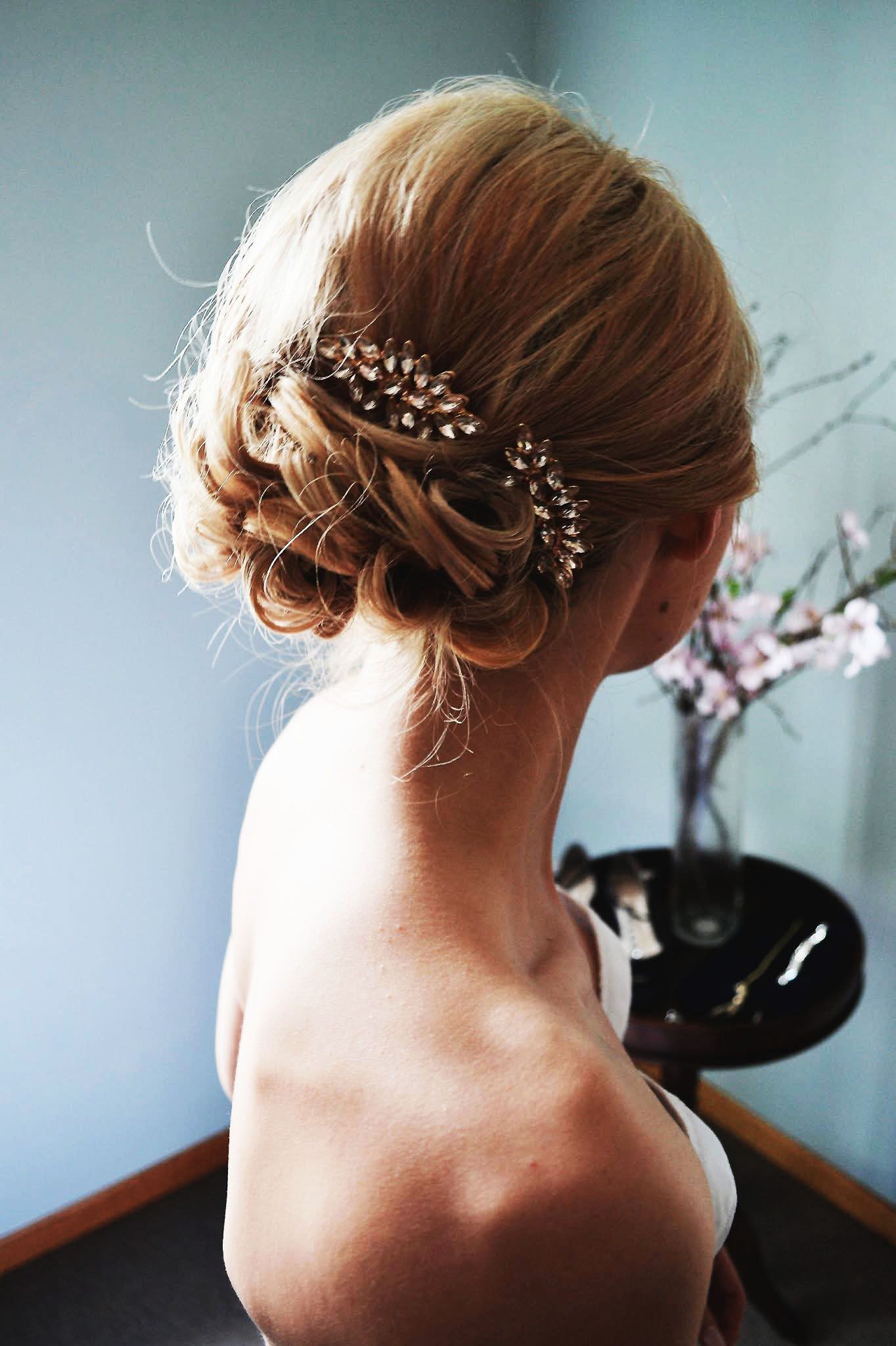 A woman in a white dress has her hair in a bun.