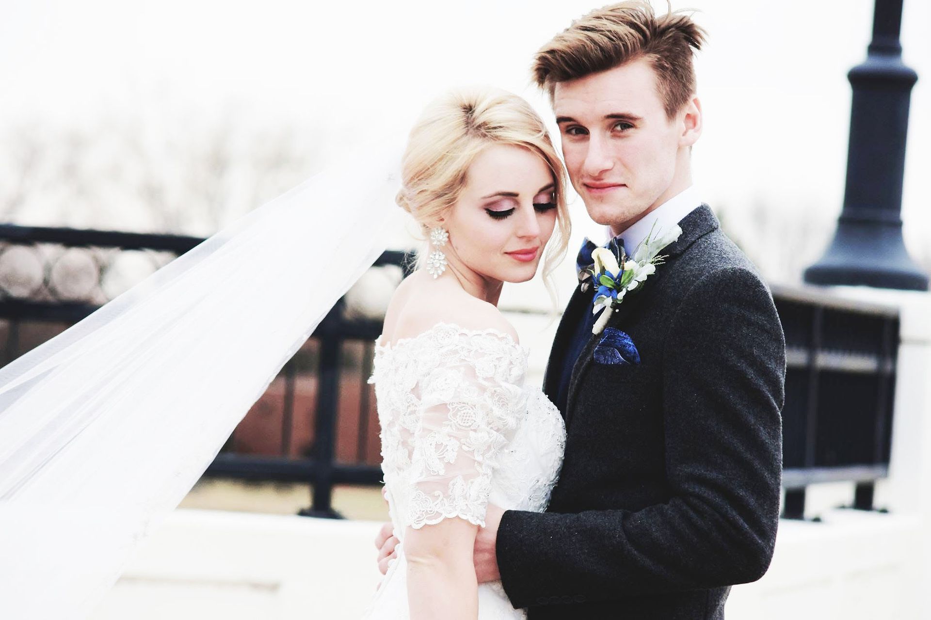 A bride and groom are posing for a picture on their wedding day.