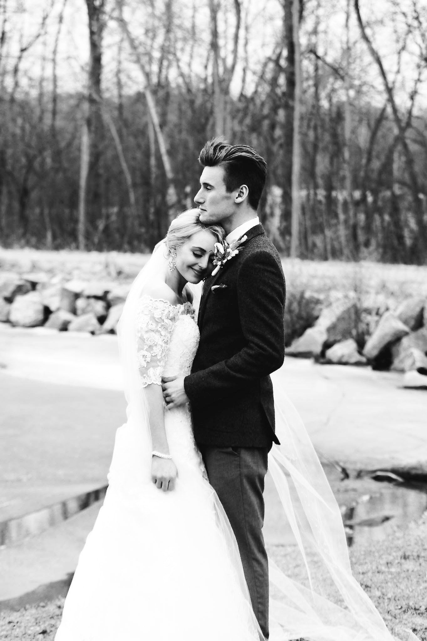 A black and white photo of a bride and groom standing next to each other.